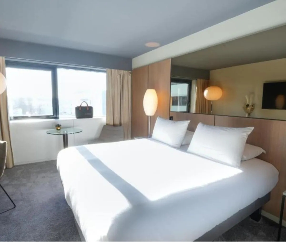 Superior room with a double bed, armchair and floor lamp at Pullman Bordeaux Lac, Bordeaux