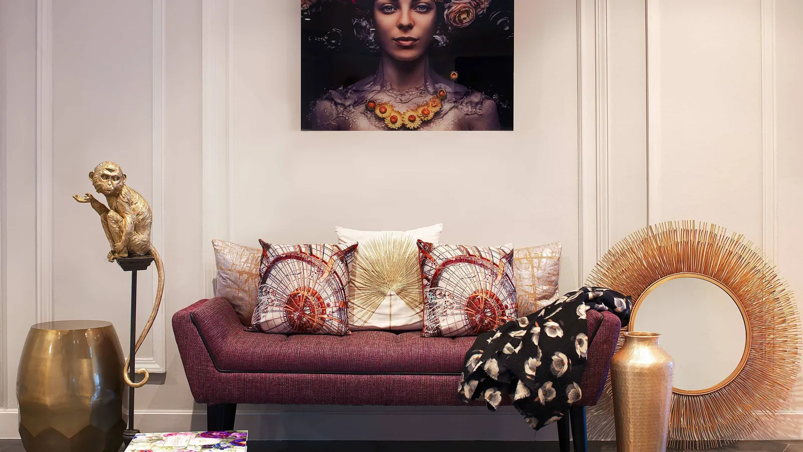 Lounge sofa with patterned cushions and a framed portrait at Renaissance Paris La Défense Hôtel