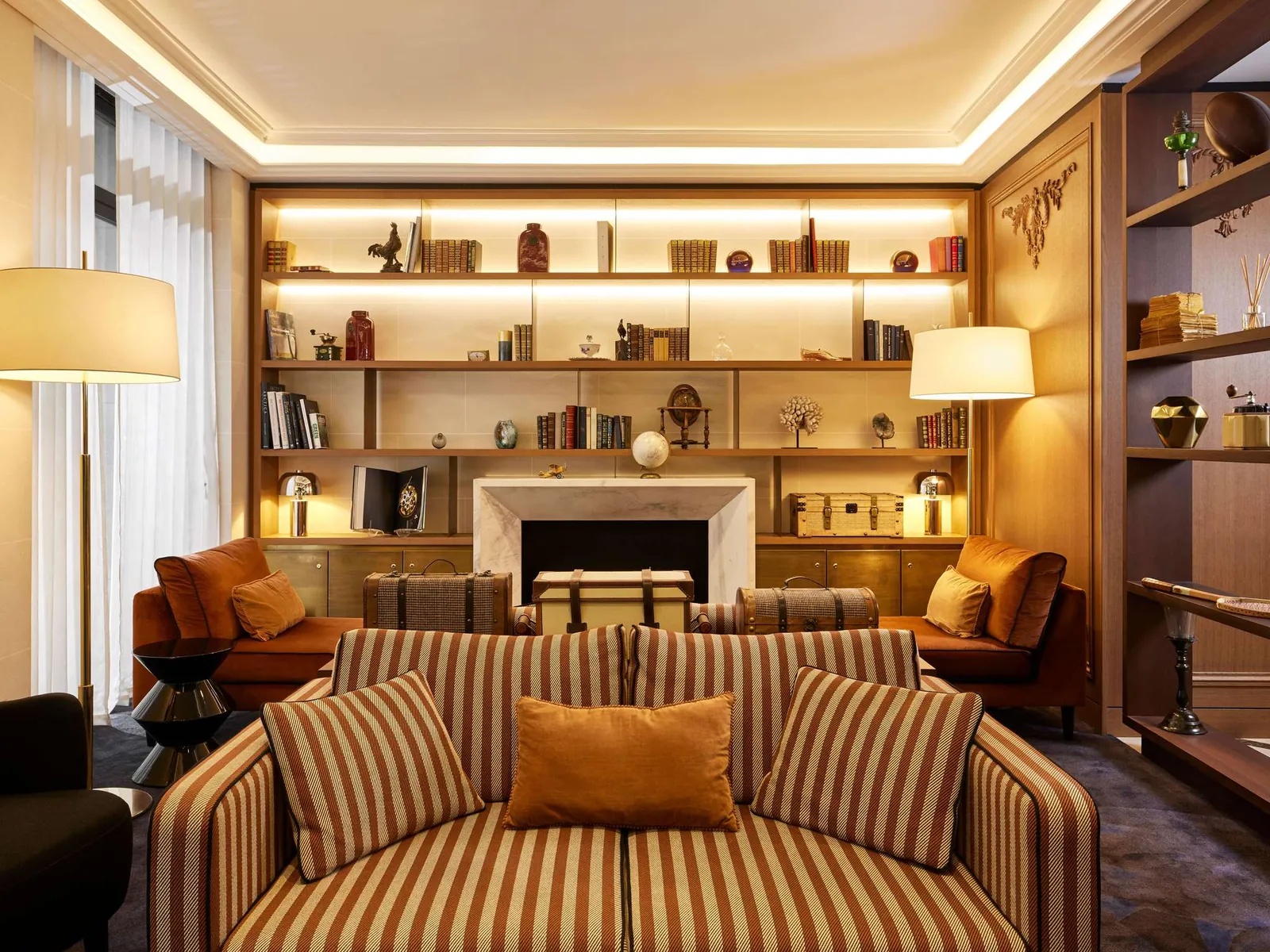 Lounge with bookshelves and a fireplace at Sofitel Paris Baltimore Tour Eiffel, a hotel in Paris 16e