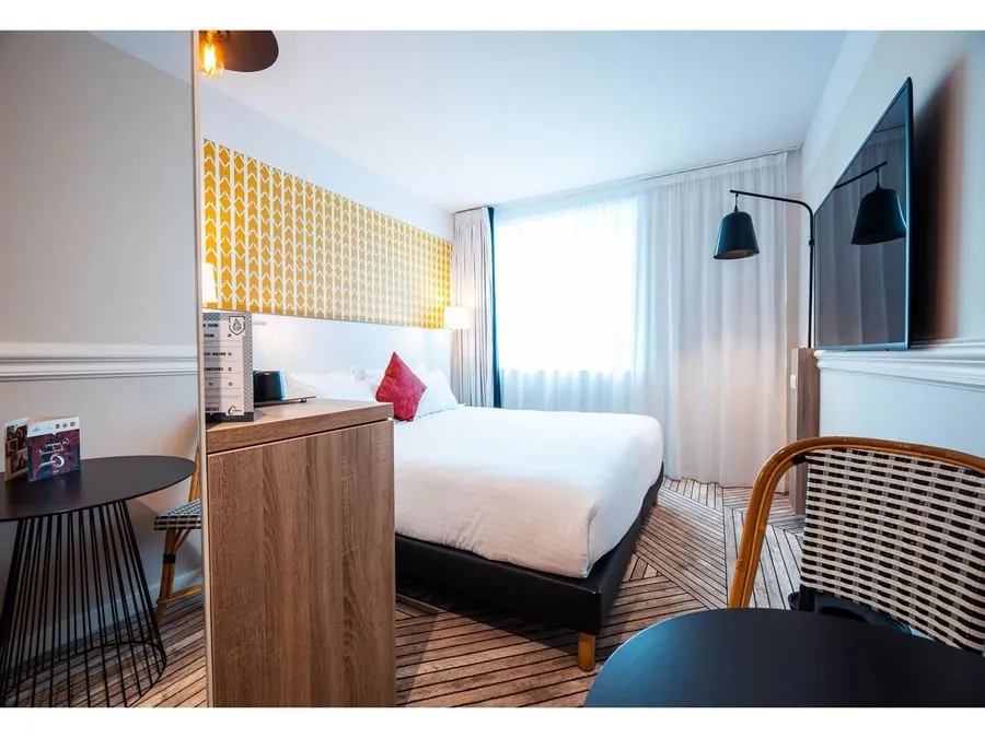 Double guest room at The Originals Boutique Hôtel Maison Montmartre with a yellow patterned wall panel