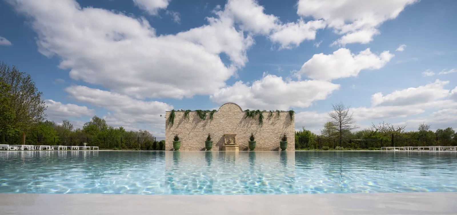Lakeside view of the château ruin and reflecting pool at Vienna House Dream Castle Paris