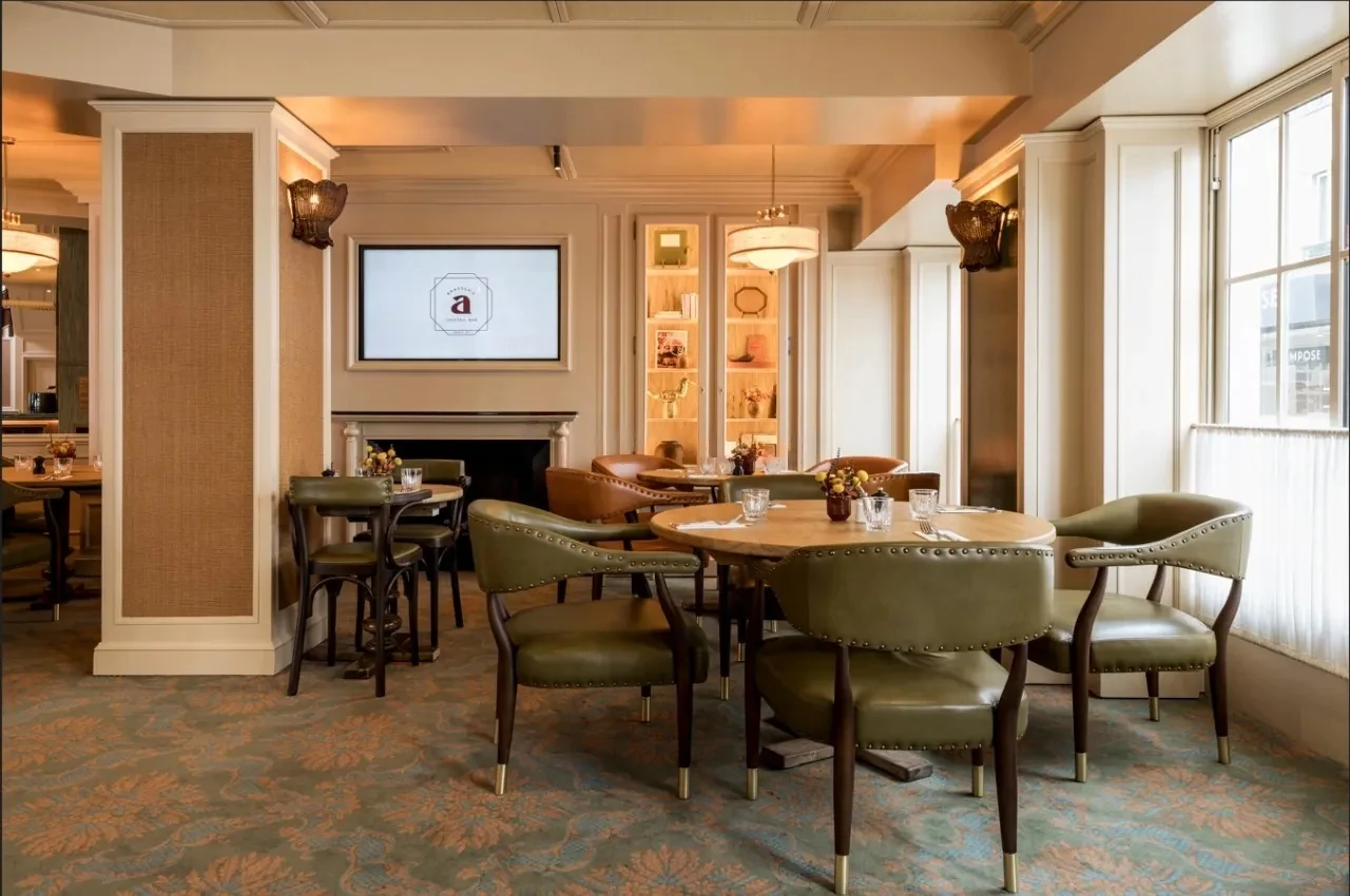 Dining area with velvet armchairs and a wall screen