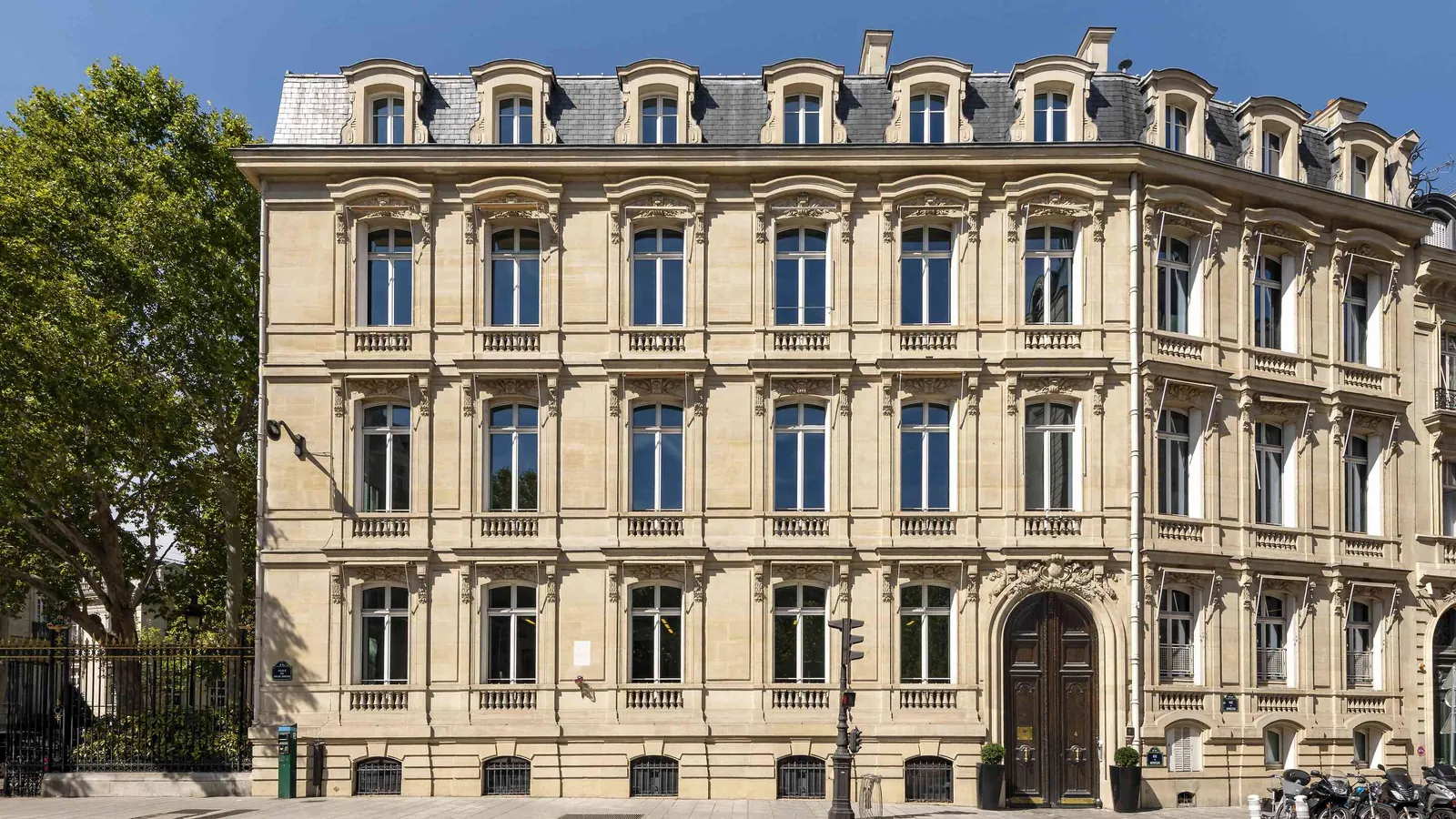 Light Atelier facade in cream stone with tall windows and a steep roof with dormers