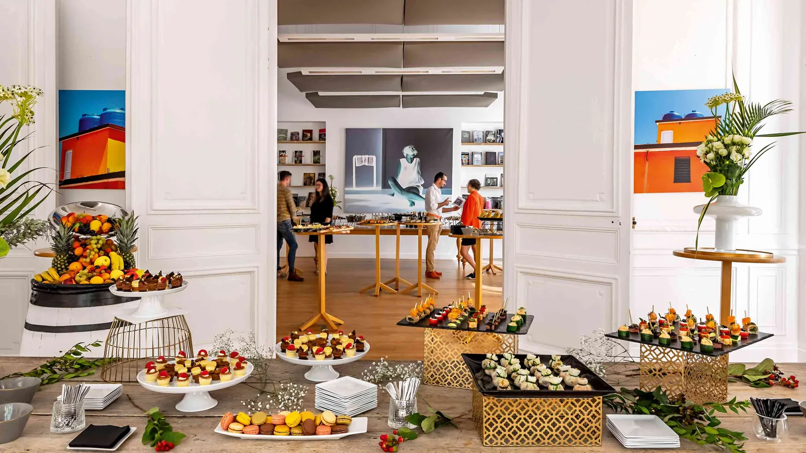 Light Atelier reception with fruit displays, buffet tables and guests in daylight