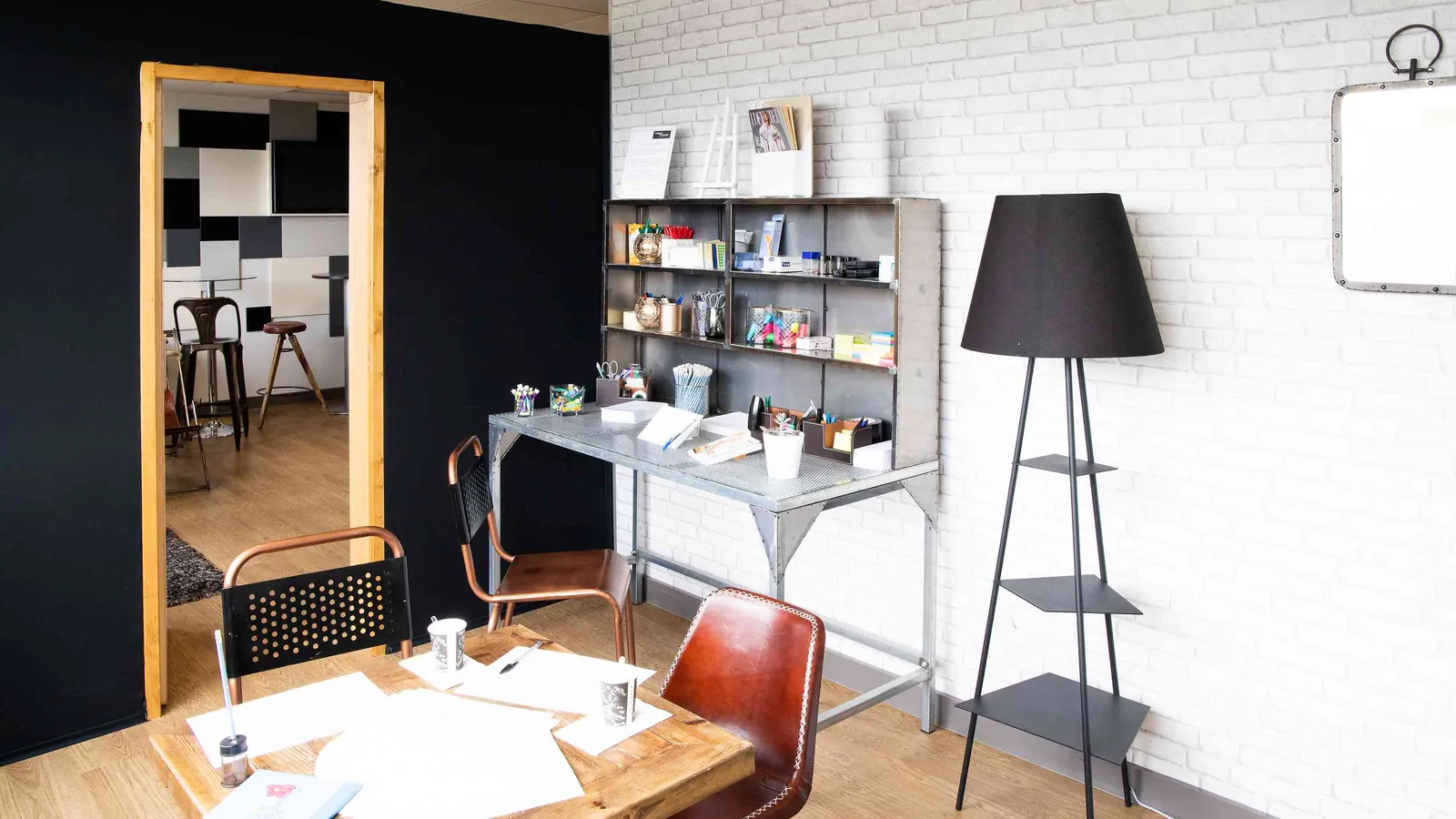 Northern Workshops small room with a tall mirror, a worktable, shelves and a floor lamp