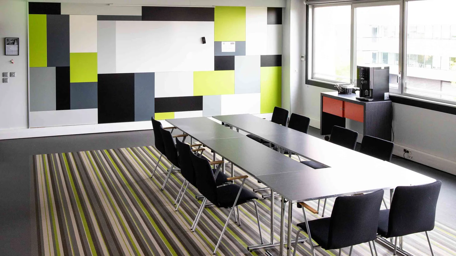 Northern Workshops boardroom layout with a long central table and a wall-mounted screen