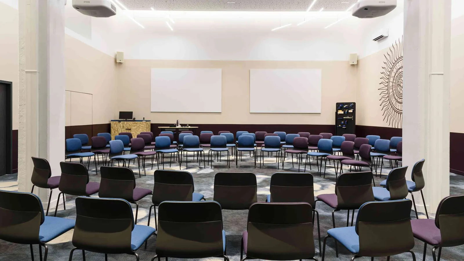 North Belvedere auditorium with rows of blue and grey seats facing two wall screens