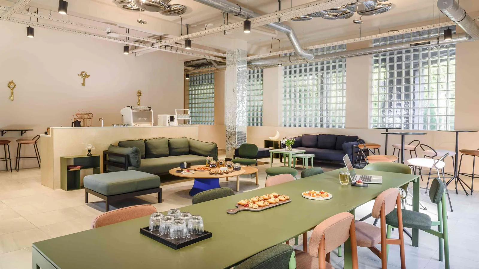 North Belvedere lounge with green and blue sofas, a low table, bar stools and a long counter