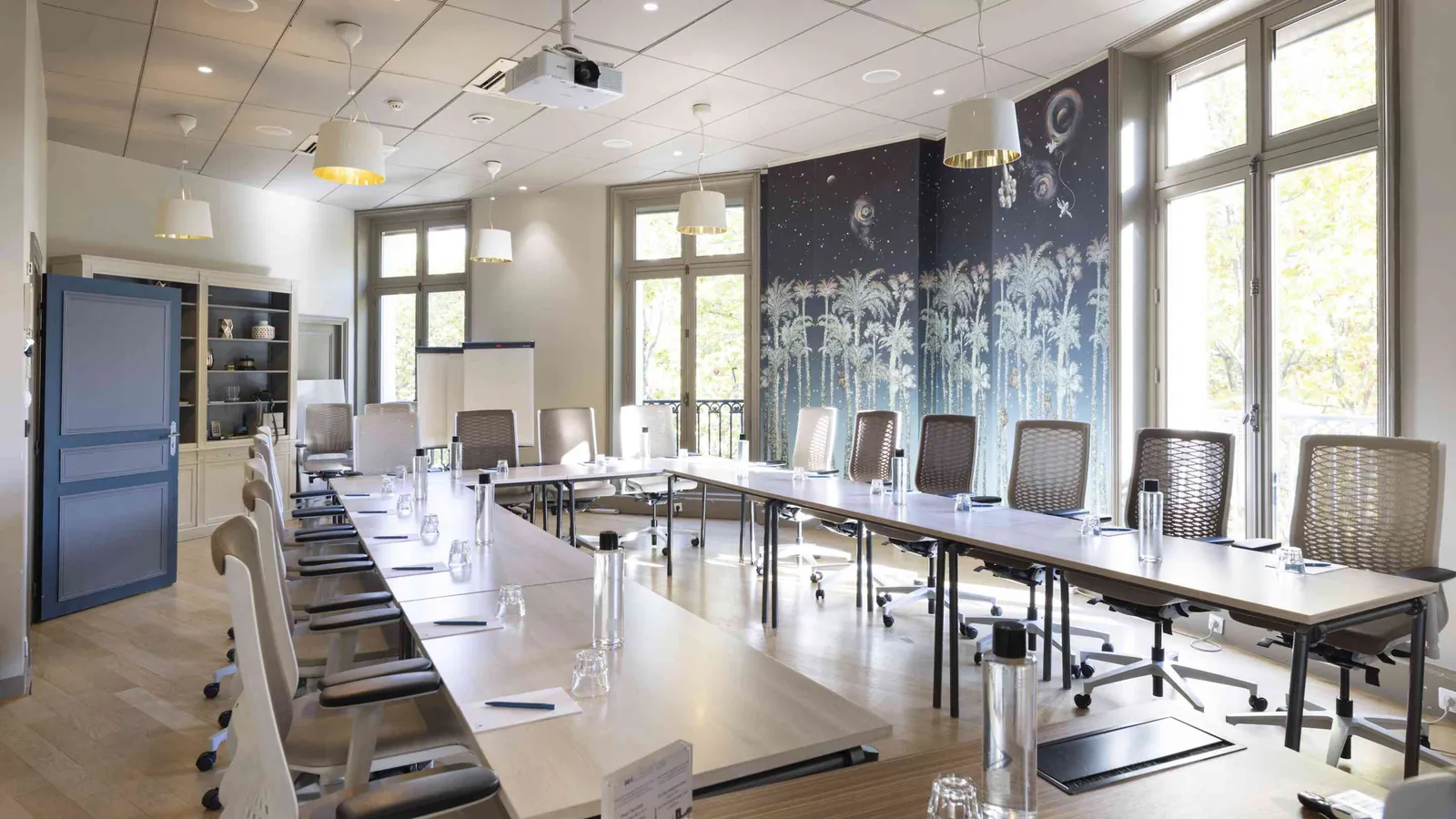 Discreet Circle meeting room with a long table, daylit windows, office chairs and a projector