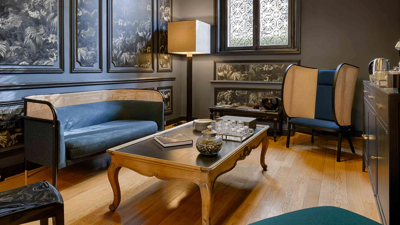 Discreet Circle lounge with a blue sofa, a carved coffee table and panelled walls