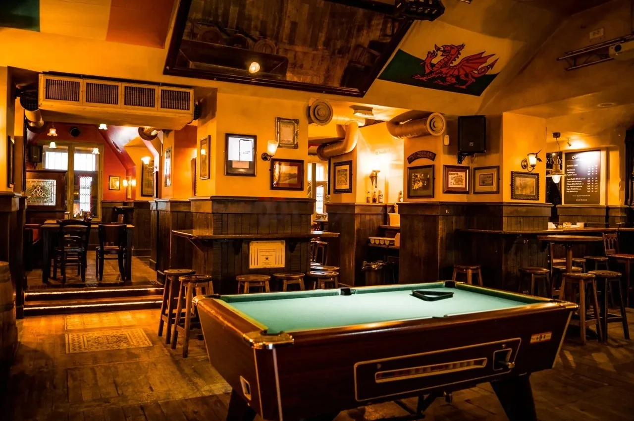 Pub room with a pool table and a wooden bar