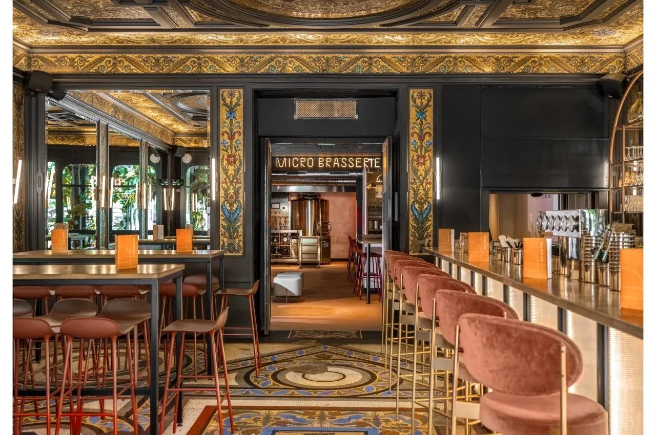 Bar area with upholstered high stools and a gilded ceiling