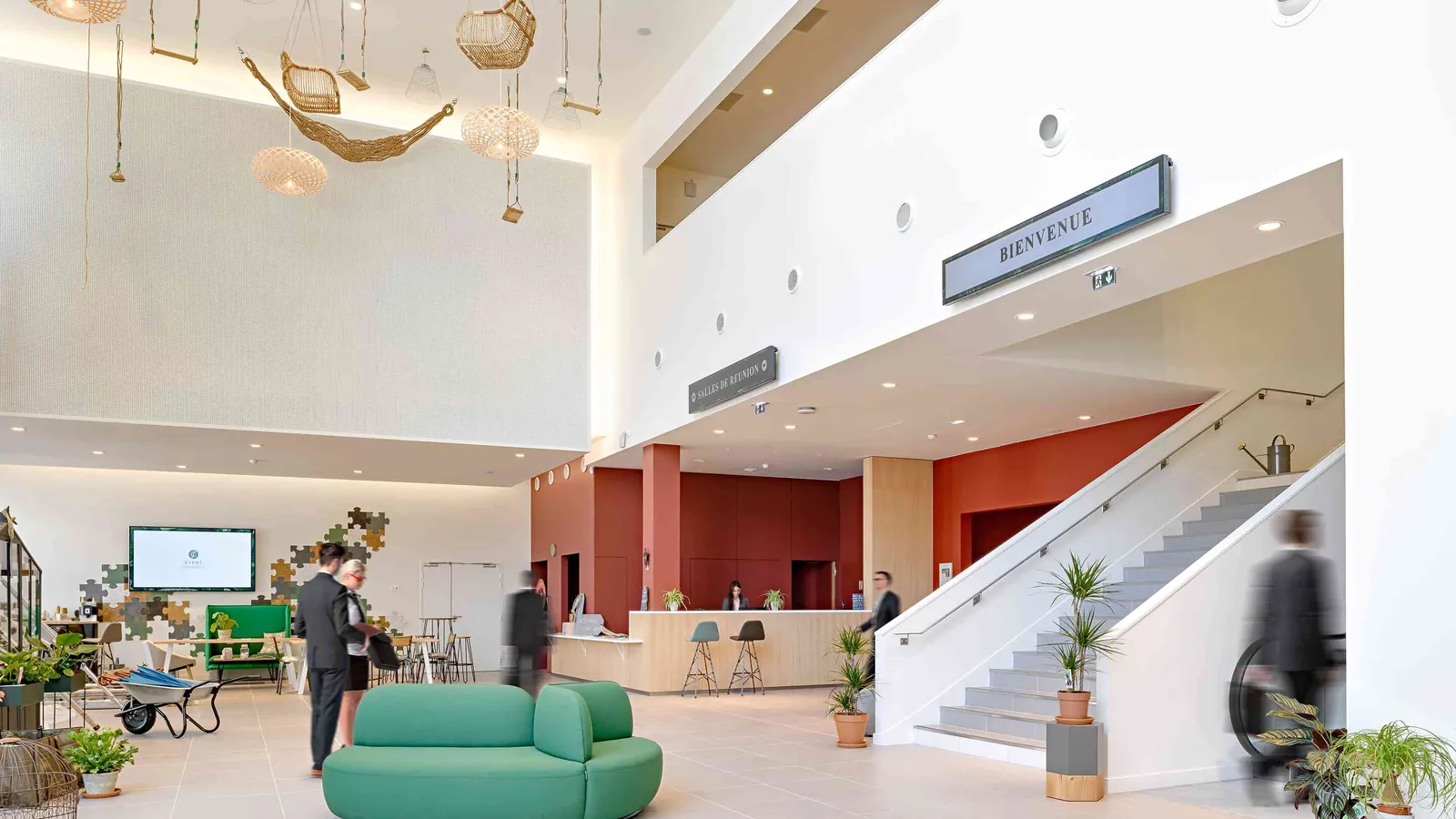 Horizon Forum welcome hall with a grand staircase, a green sofa and a wall-mounted sign
