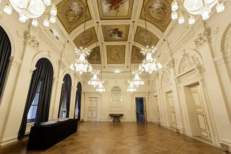 Ballroom with a painted ceiling, crystal chandeliers and tall arched windows