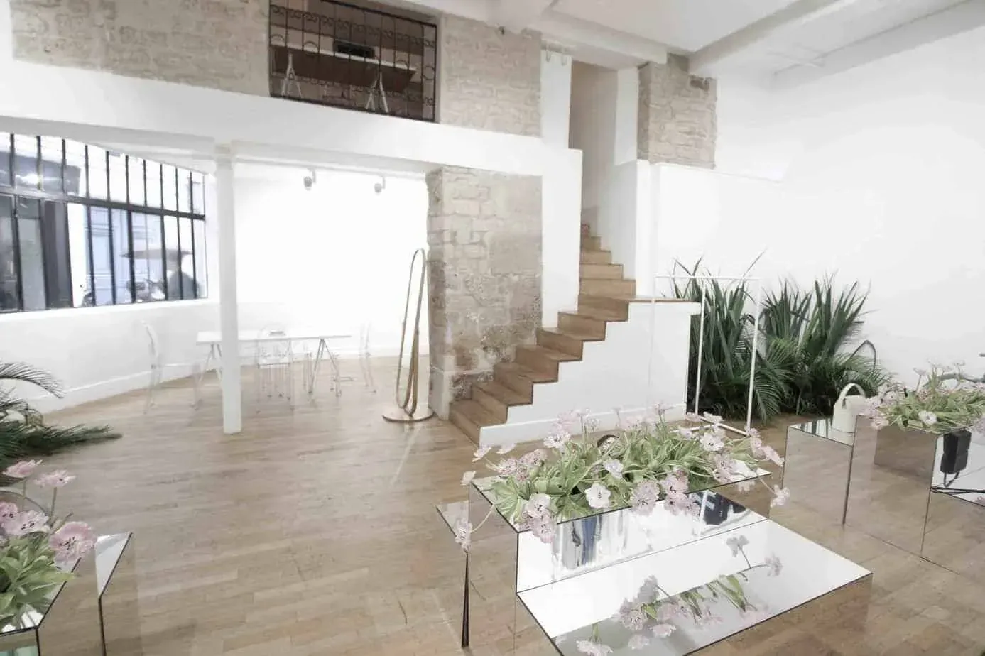 Table dressed with flower arrangements beside a wooden staircase