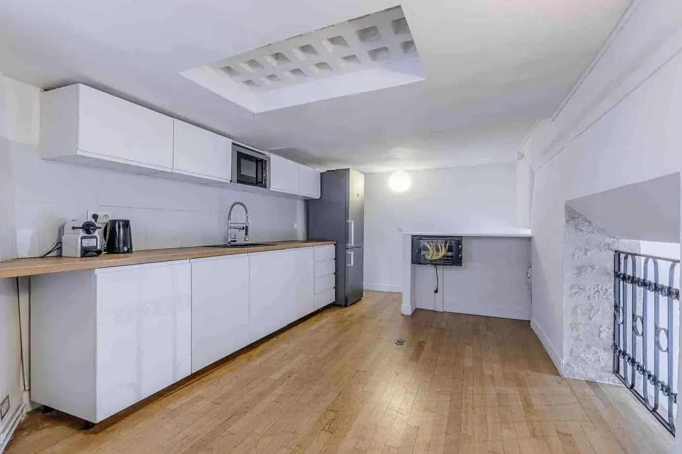 Kitchen with white cabinets and a stone wall
