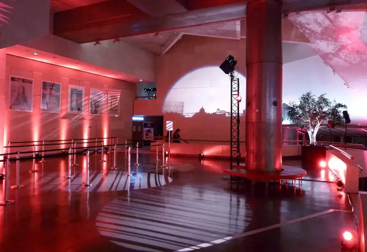 Red-lit area beside a steel column with a projection on the wall