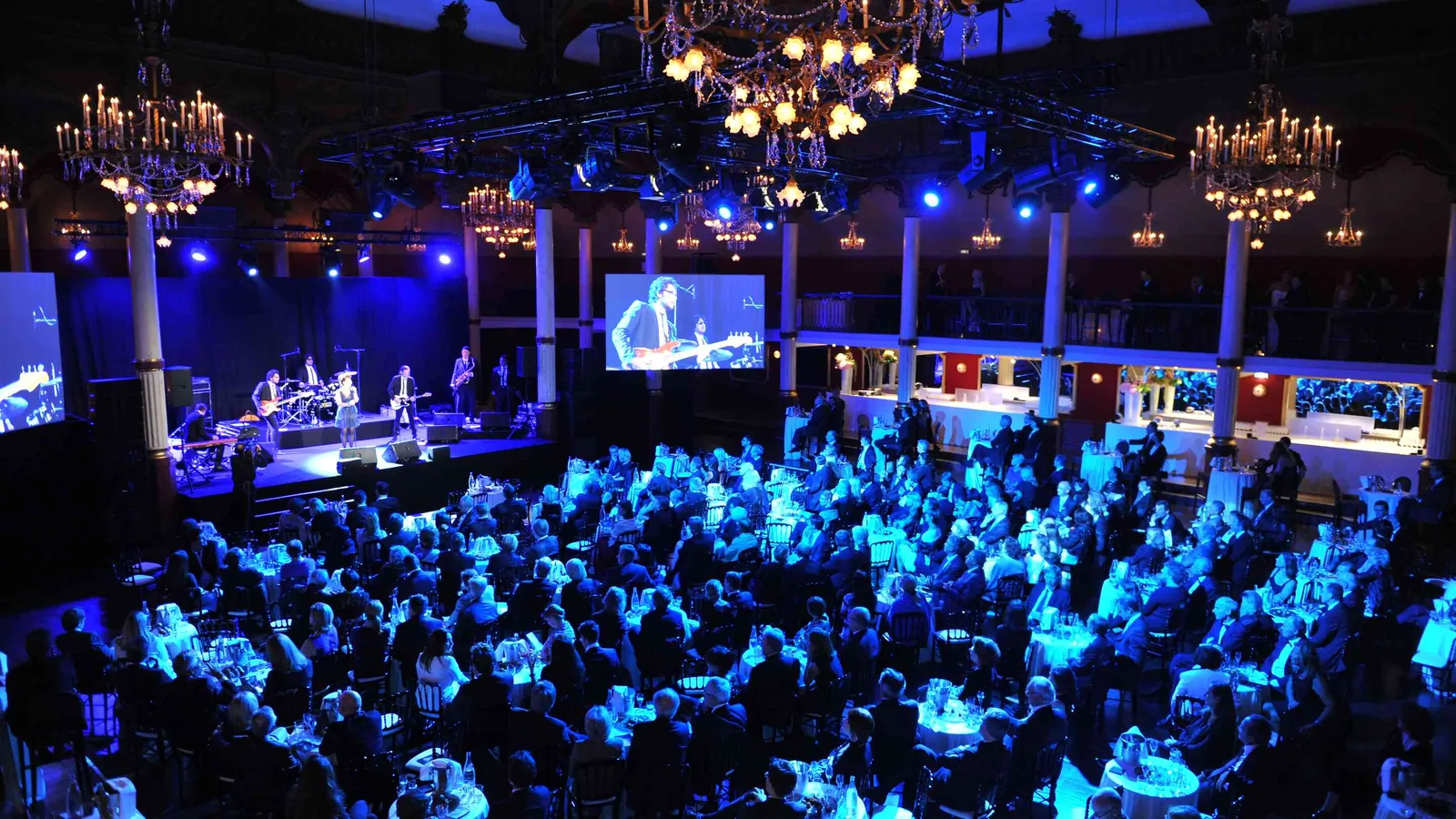 Étoile Grand Hall evening event with a stage, blue lighting and a seated audience