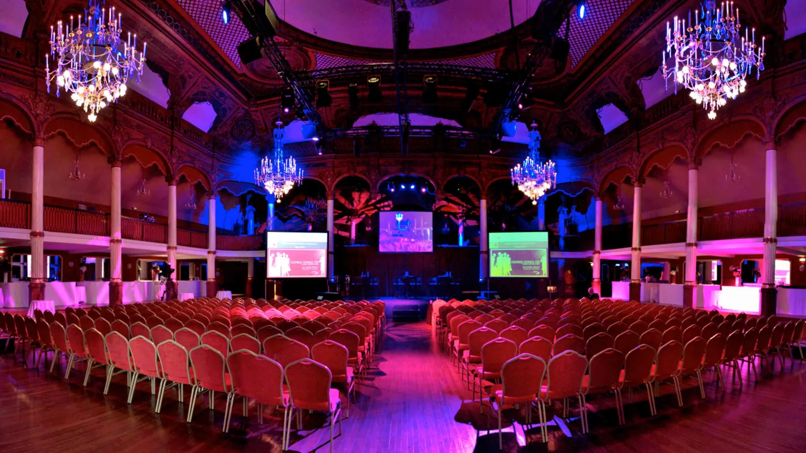 Étoile Grand Hall set for a show, with red chairs in rows facing a stage and screens
