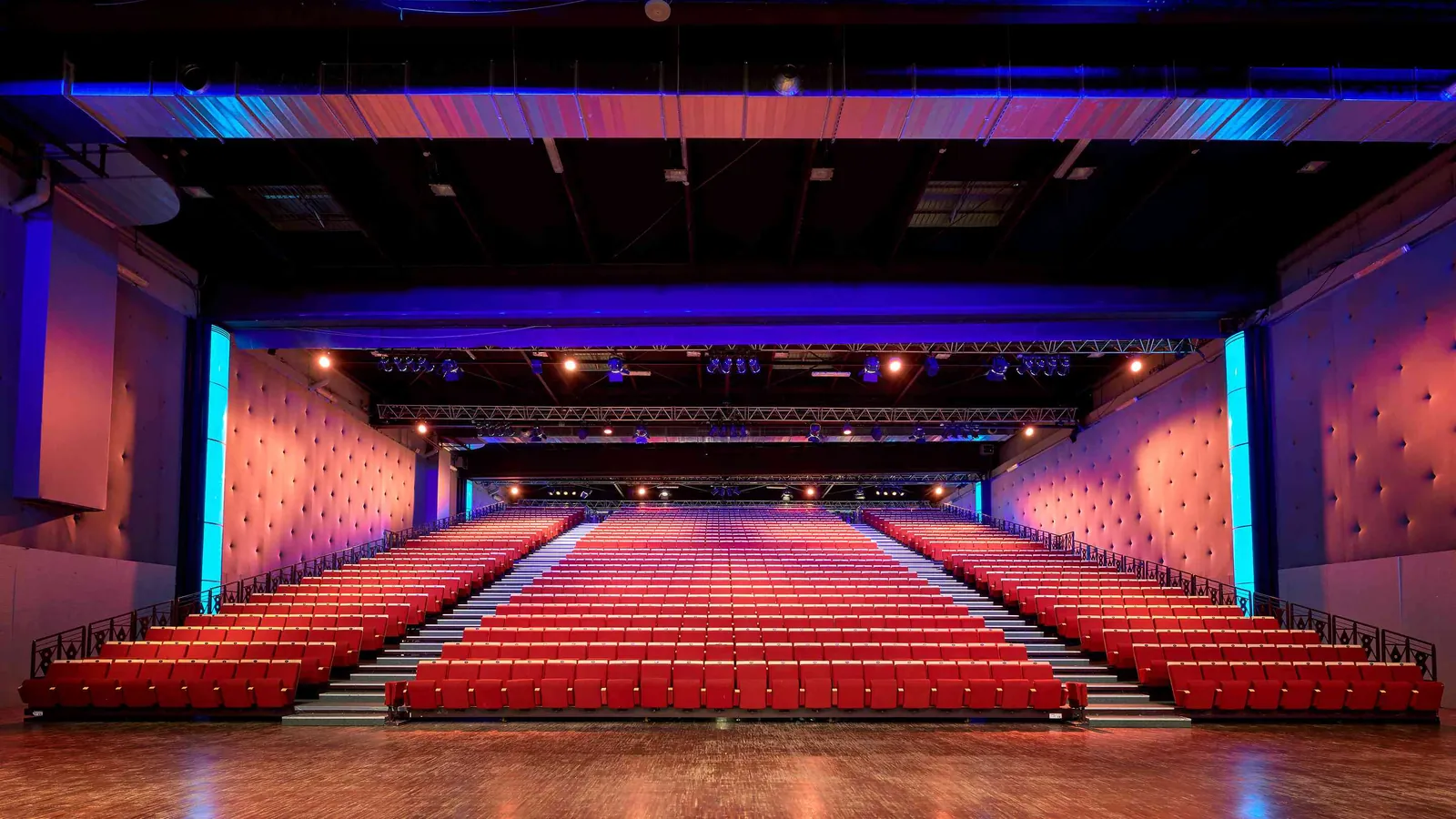 Seine Grand Halls theatre-style hall with red seats in rows under blue stage lighting