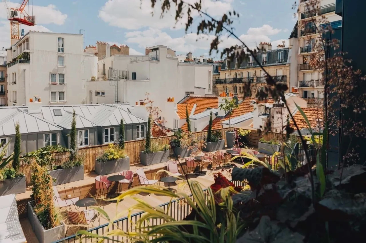 Rooftop terrace with planters and Parisian rooftops in the background.