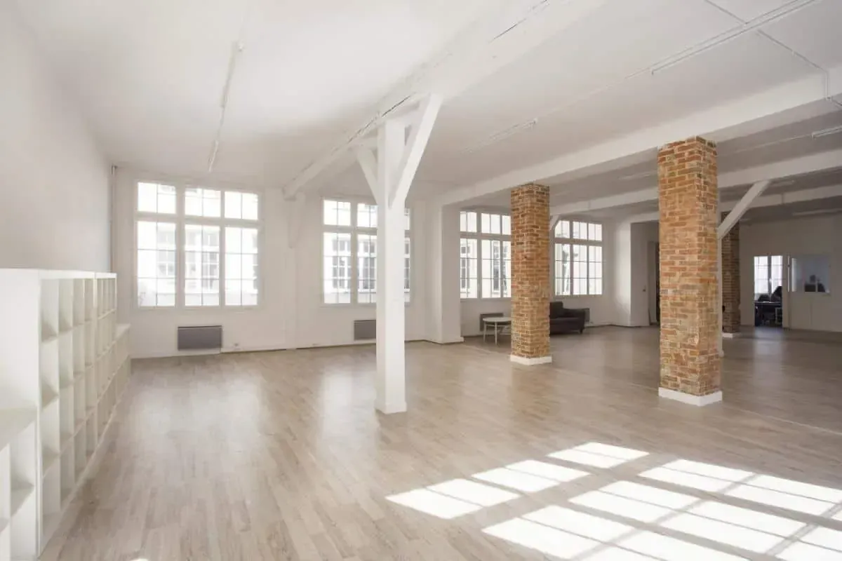 Open loft space with brick columns and sunlight on the floor