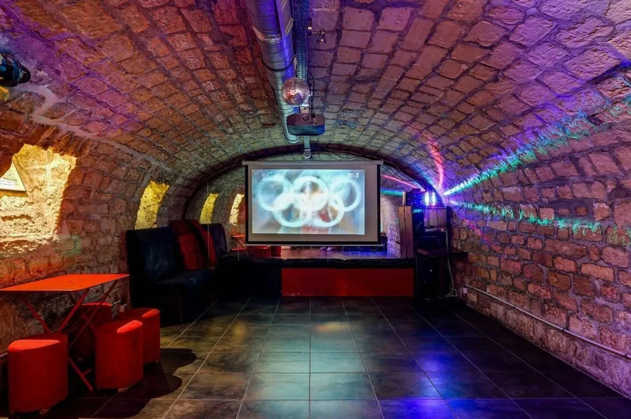 Cellar lounge with a projector and wall-mounted artworks