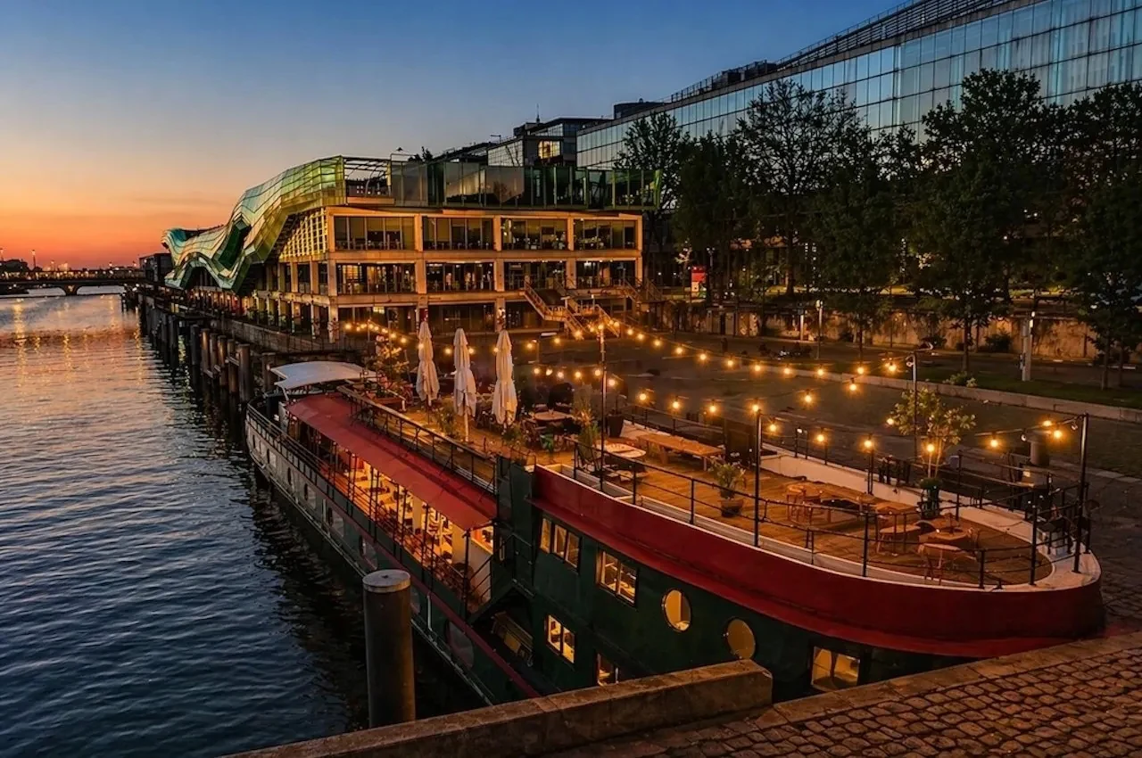 Event boat moored on the Seine at dusk with string lights