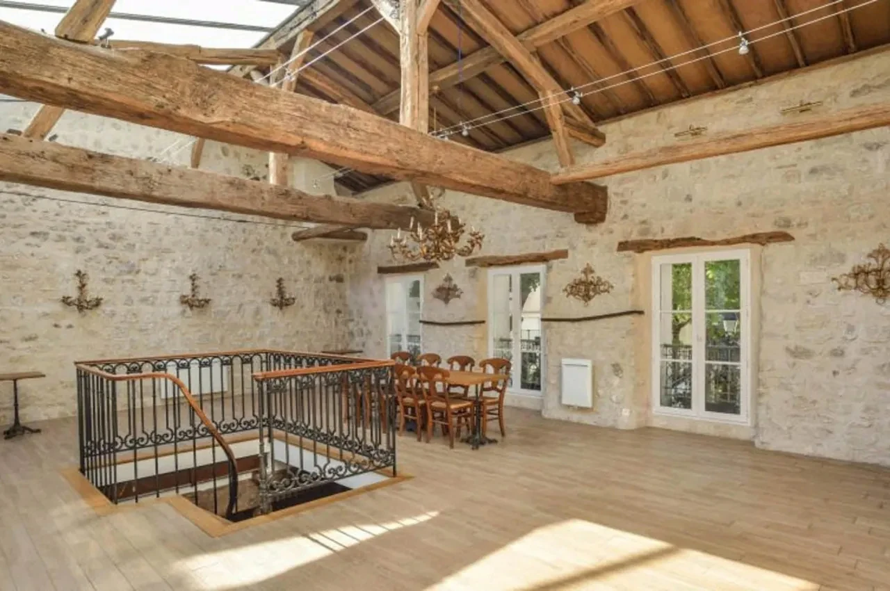 Hall with exposed timber trusses and tables near the windows
