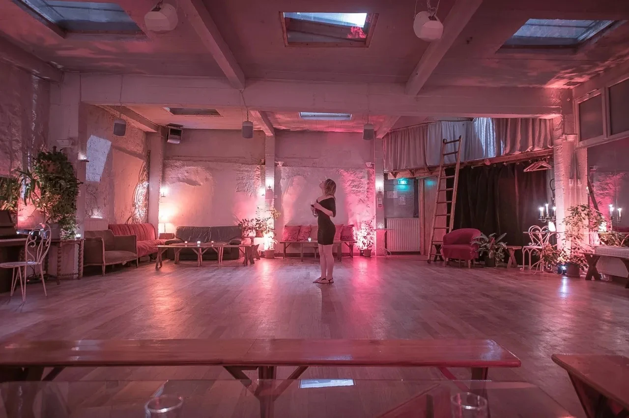 Pink-lit loft with tables and plants