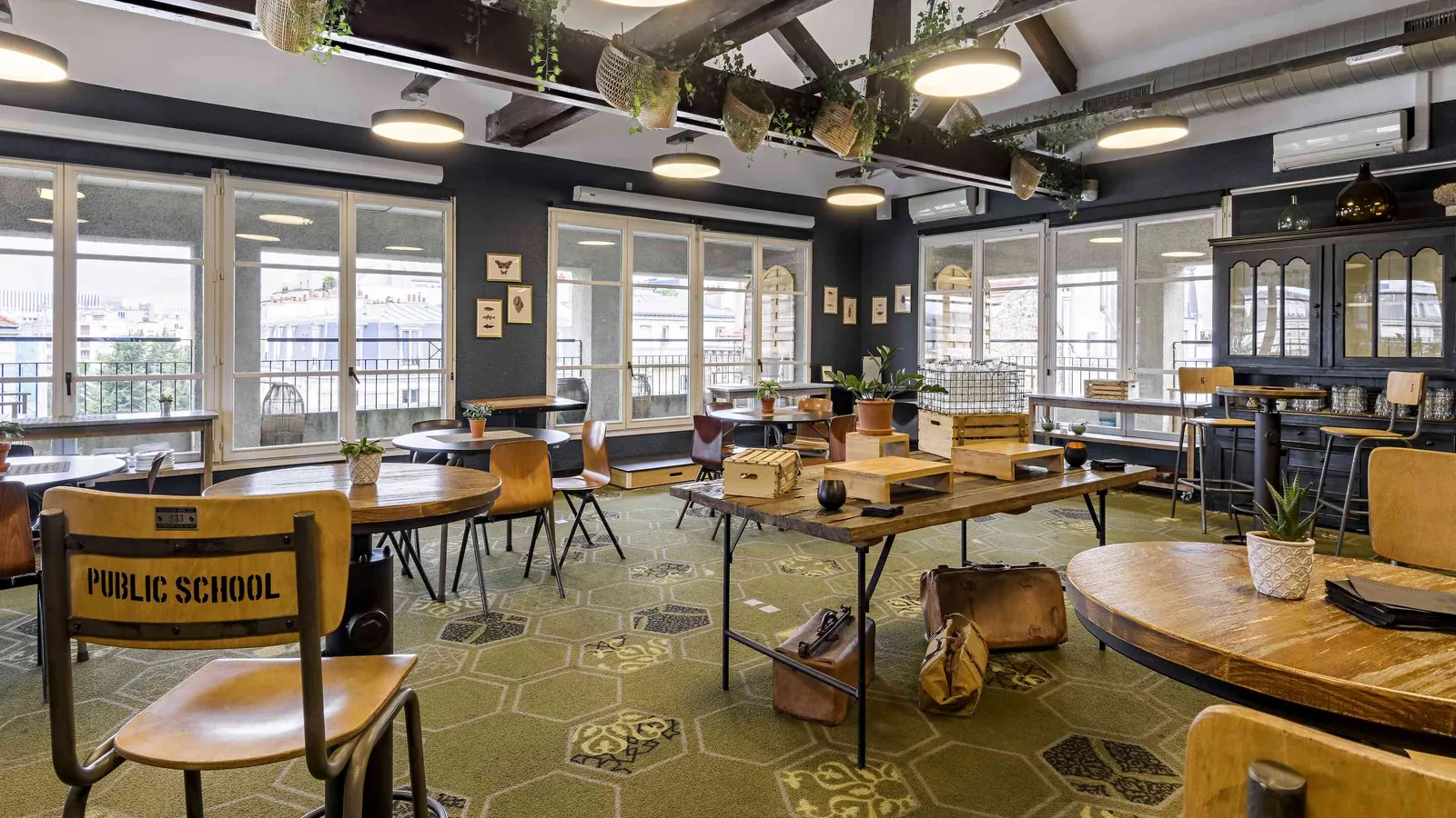 Workshop House café room with vintage school chairs, a hexagon carpet and a long bar