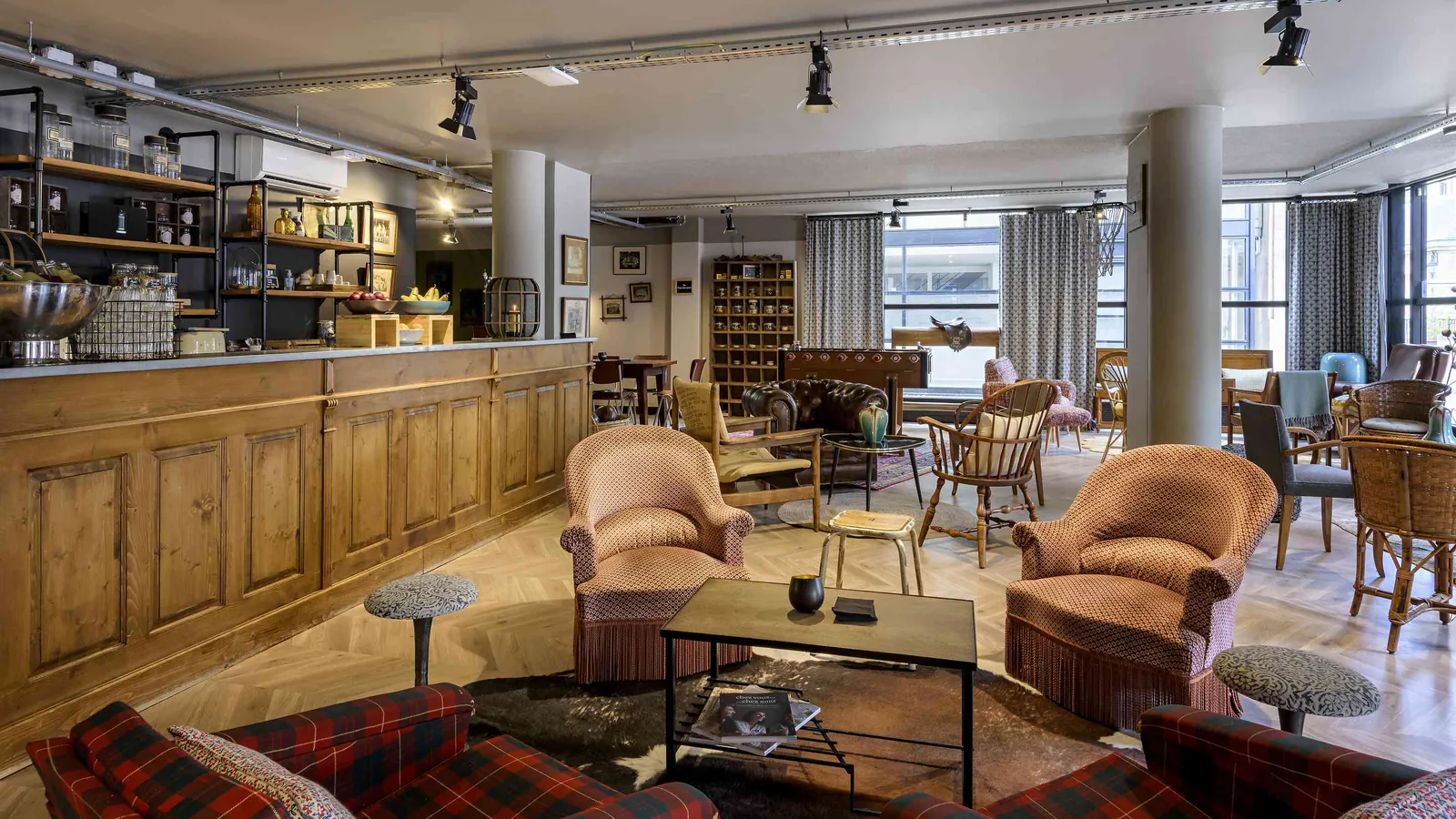 Workshop House lounge bar with leather armchairs, a wooden counter and vintage lamps