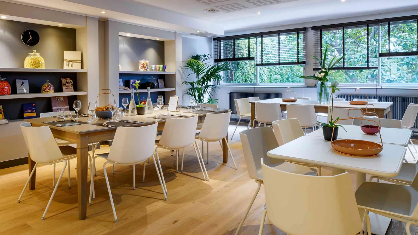 Golden House meeting room with a wooden table, white chairs and a wall of shelves