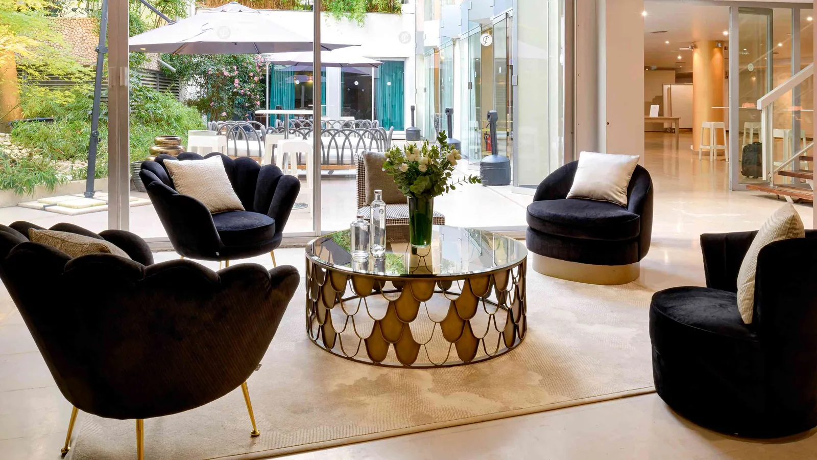 Golden House lounge with black velvet armchairs, a gilded marble table and garden view