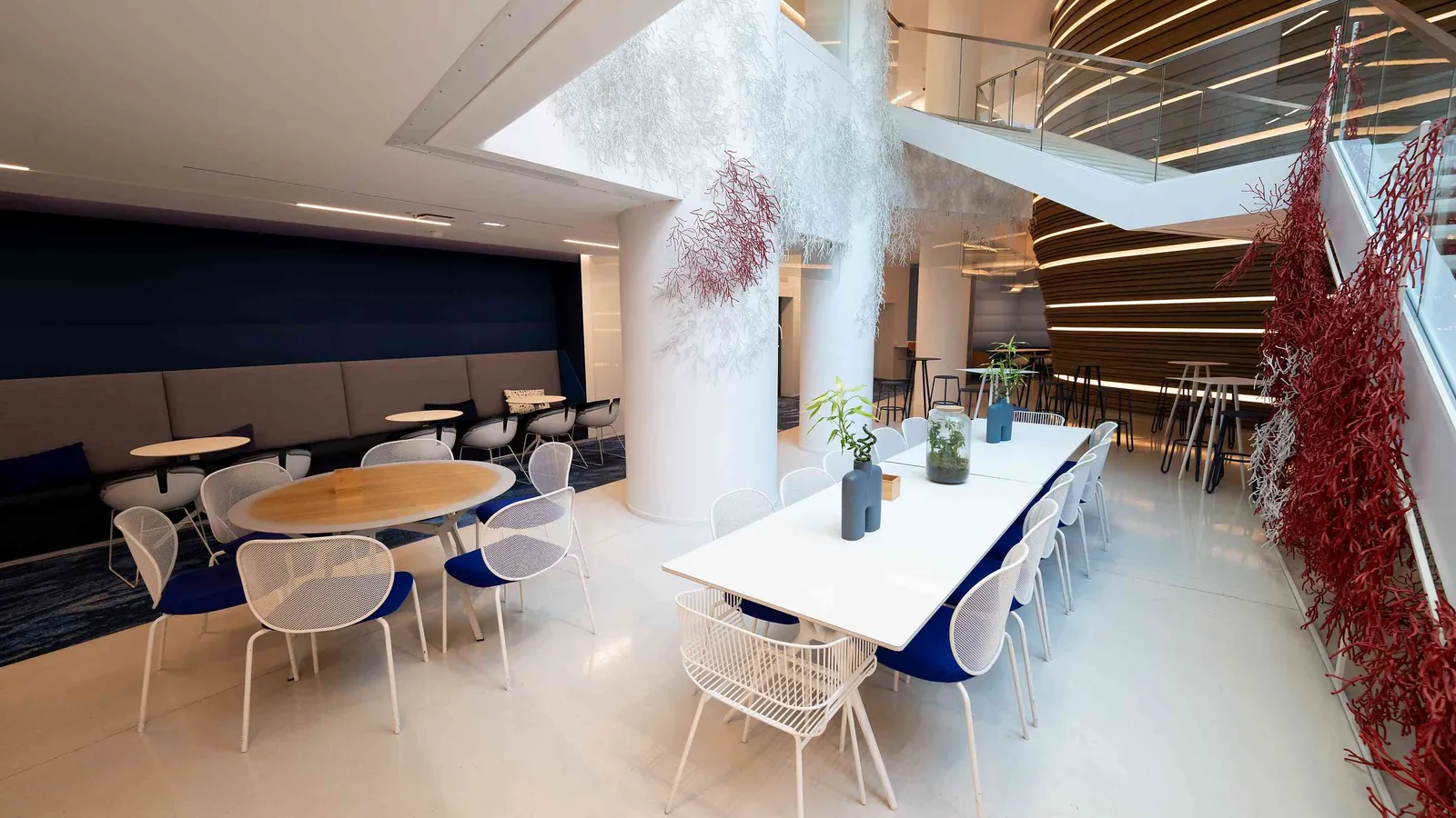 Contemporary Pavilion lounge with a long white table, blue chairs and dried red branches