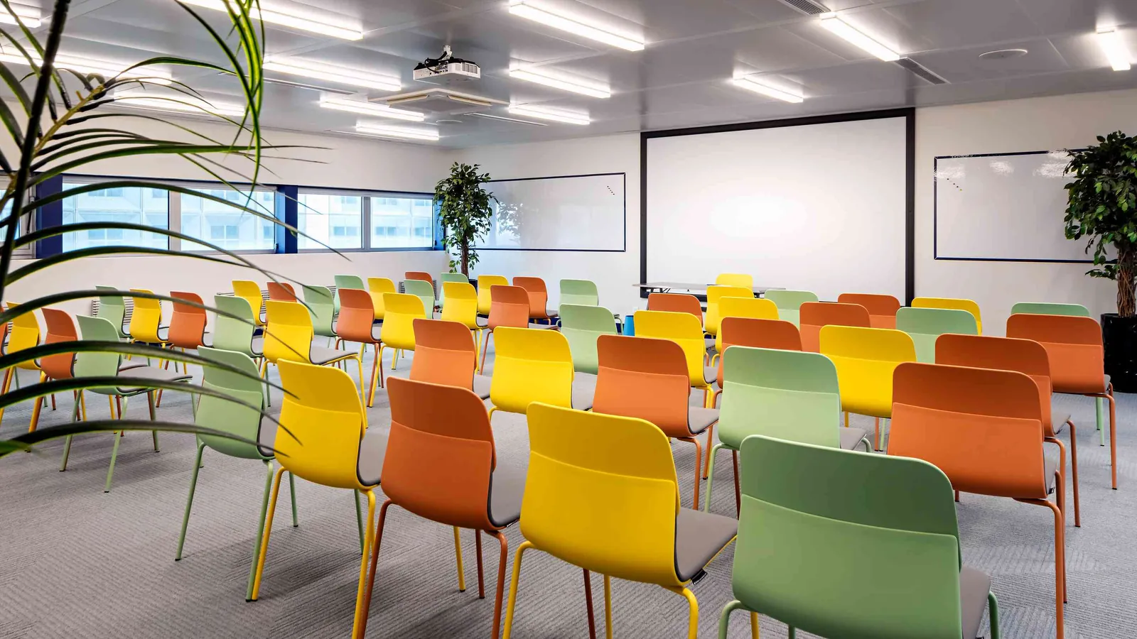 West Pavilion large training room with a projection screen and rows of colourful chairs