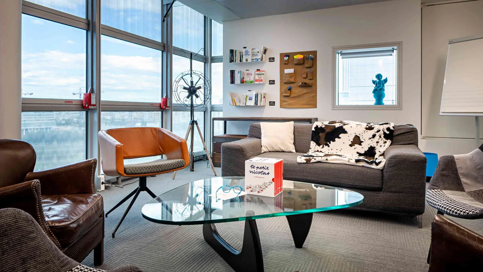 West Pavilion lounge with a leather armchair, a glass coffee table and city views