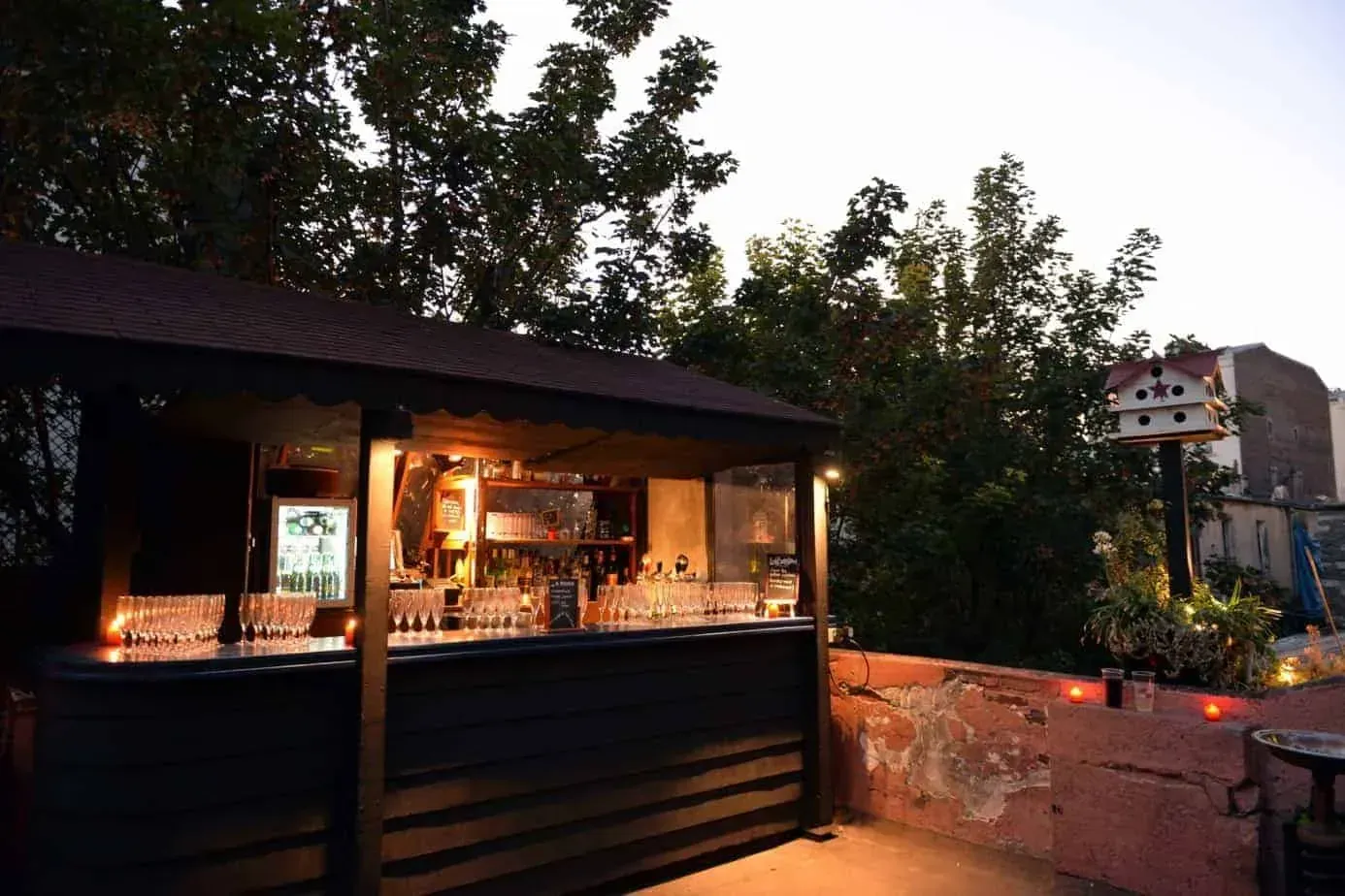 Outdoor bar kiosk with string lights at dusk